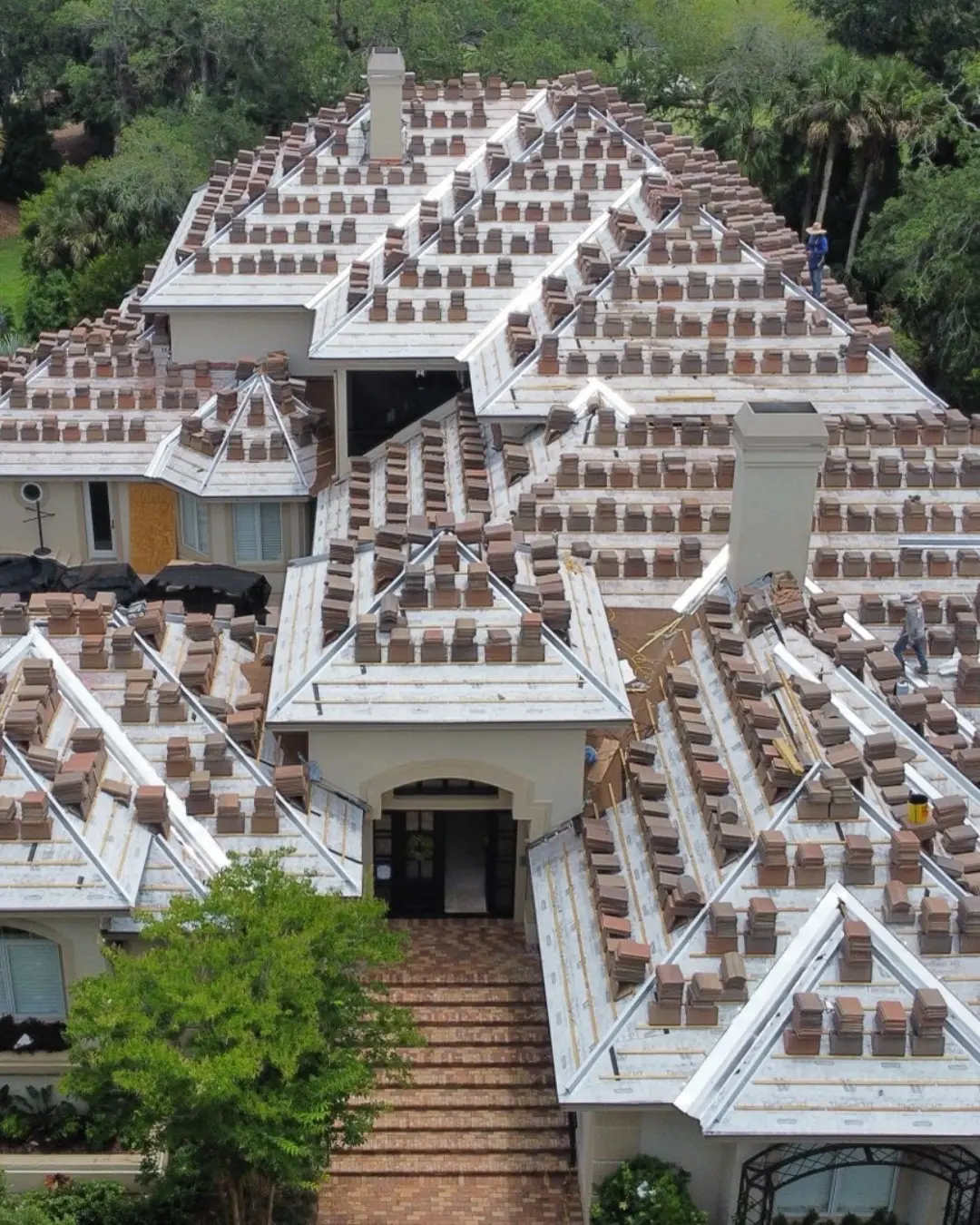 an aerial shot of a roof being worked on on a home